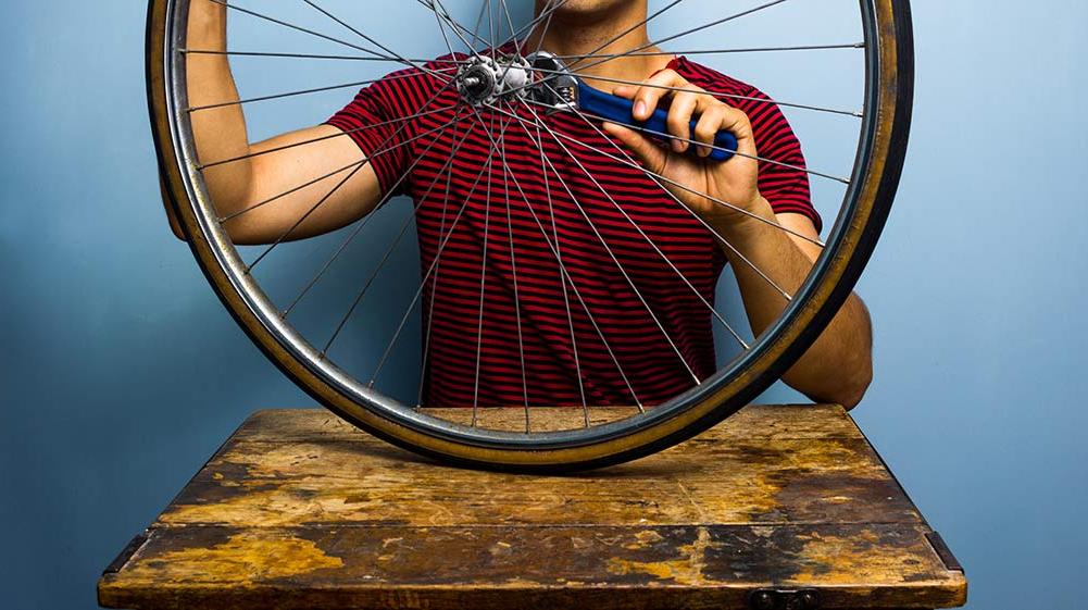 Man fixing bicycle wheel.